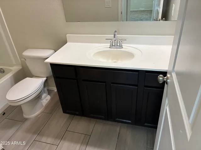 a bathroom with a sink a toilet a mirror and vanity