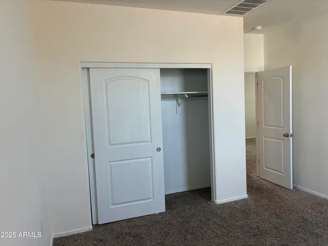 a view of empty room with closet and wooden floor