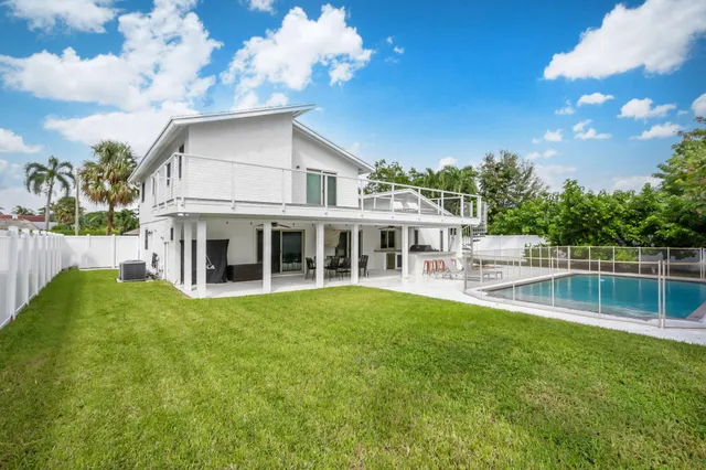 a view of a house with a yard deck and sitting area