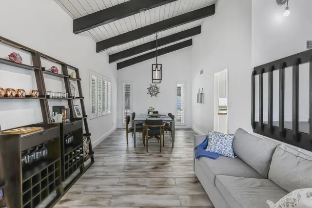 a living room with furniture flat screen tv and a large window