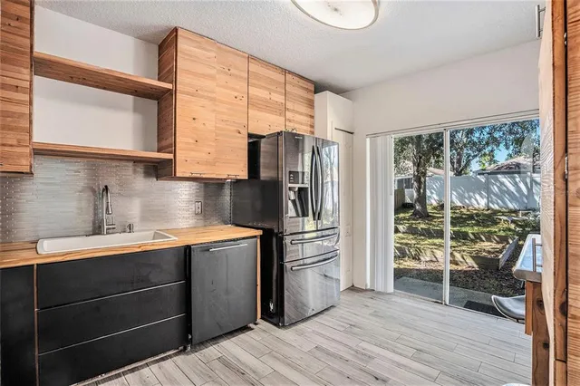 a kitchen with stainless steel appliances a sink cabinets and wooden floor