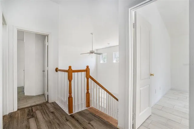 a view of a hallway with wooden floor and staircase