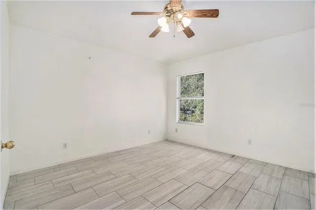 an empty room with a chandelier fan