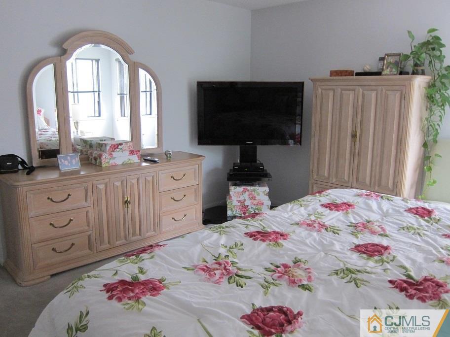 49 Park Gate Drive Edison, NJ 08820 - Photo 11 of 17 a bedroom with a bed a dresser and flat screen tv