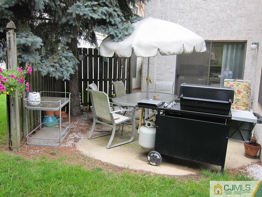 49 Park Gate Drive Edison, NJ 08820 - Photo 15 of 17 a view of a patio with table and chairs a barbeque grill and wooden fence