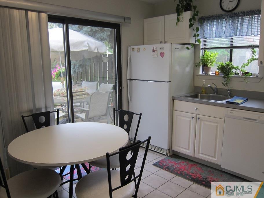 49 Park Gate Drive Edison, NJ 08820 - Photo 4 of 17 a kitchen with stainless steel appliances granite countertop a stove a refrigerator a sink a dining table and chairs with wooden floor