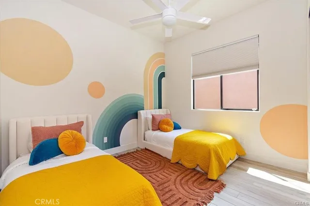 a bedroom with two beds and painting on the wall