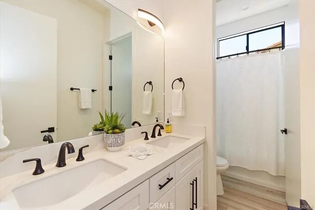 a bathroom with double sink and a mirror