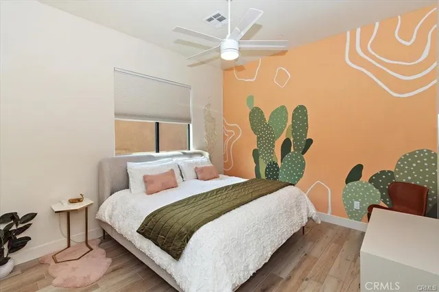 a bedroom with a bed and a painting on the wall