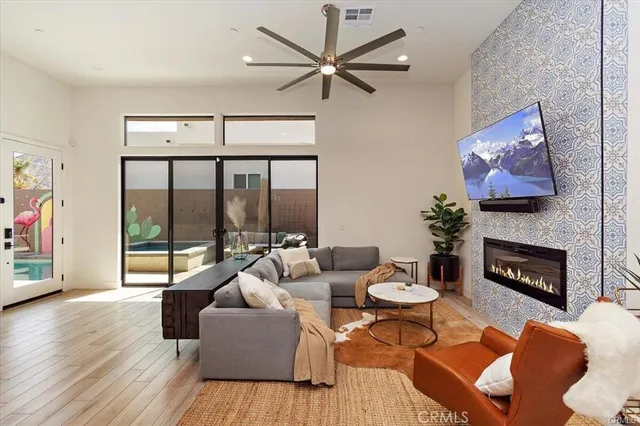a living room with furniture a fireplace and a floor to ceiling window