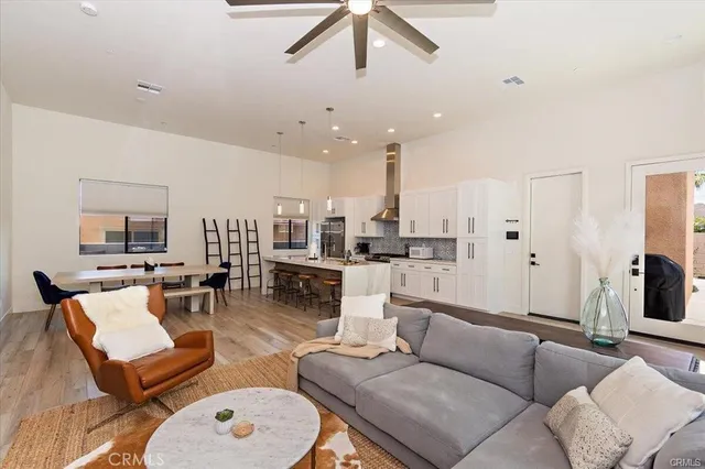 a living room with furniture kitchen view and a chandelier