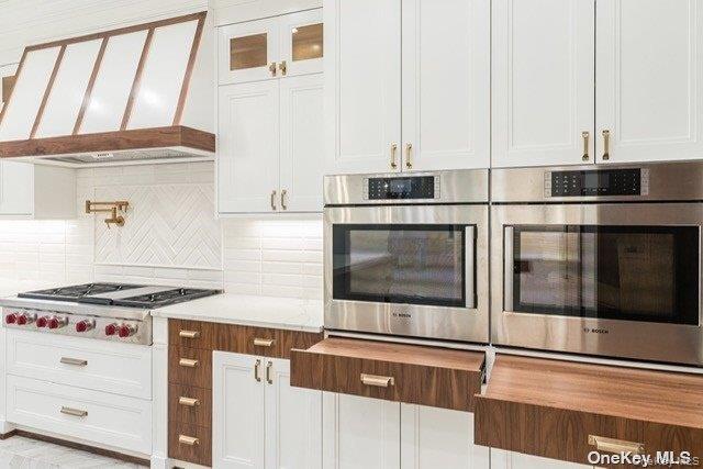 19 Gilbert Road Great Neck, NY 11024 - Photo 12 of 36 a kitchen with stainless steel appliances granite countertop a stove and a white cabinets