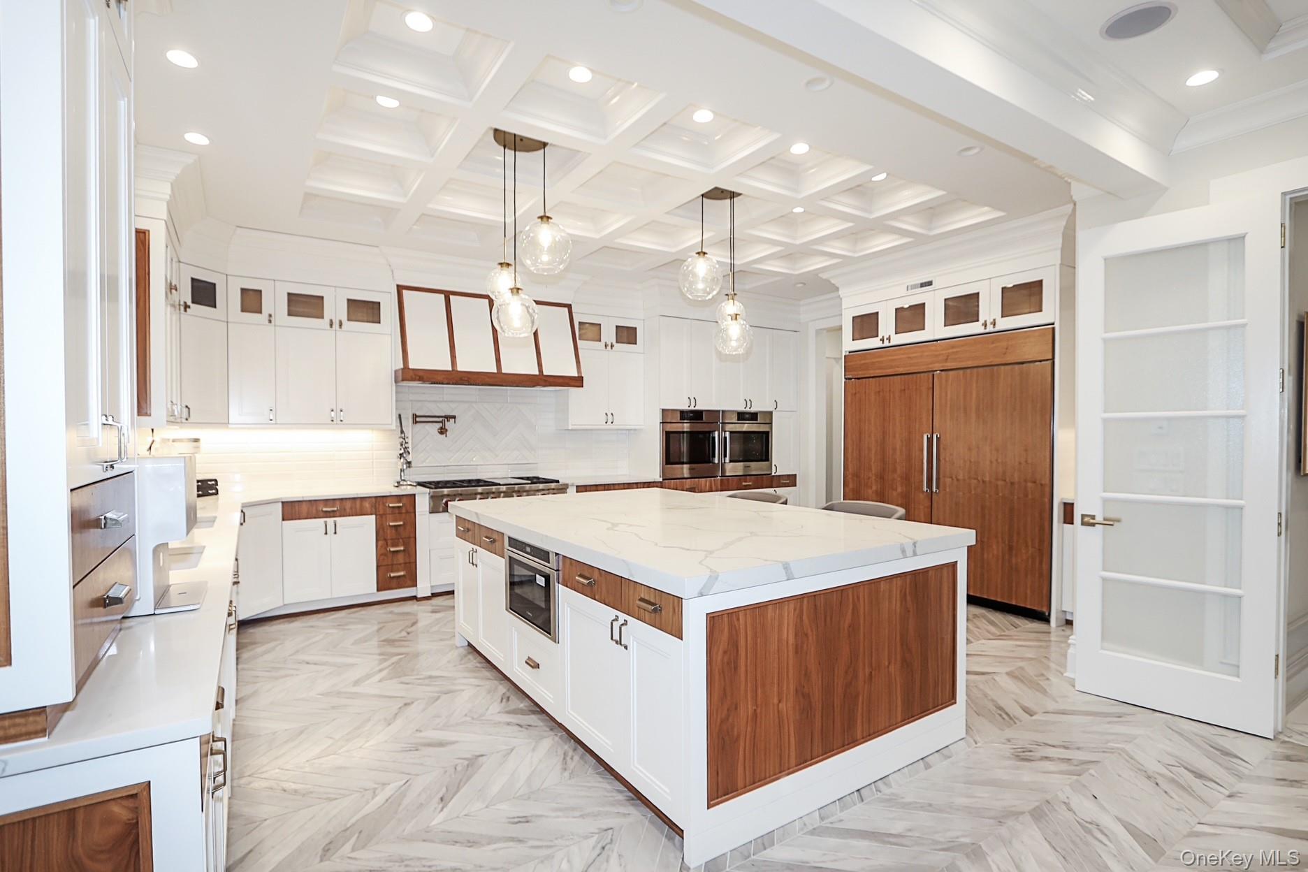 19 Gilbert Road Great Neck, NY 11024 - Photo 14 of 36 a large white kitchen with a stove a kitchen island a sink and dishwasher