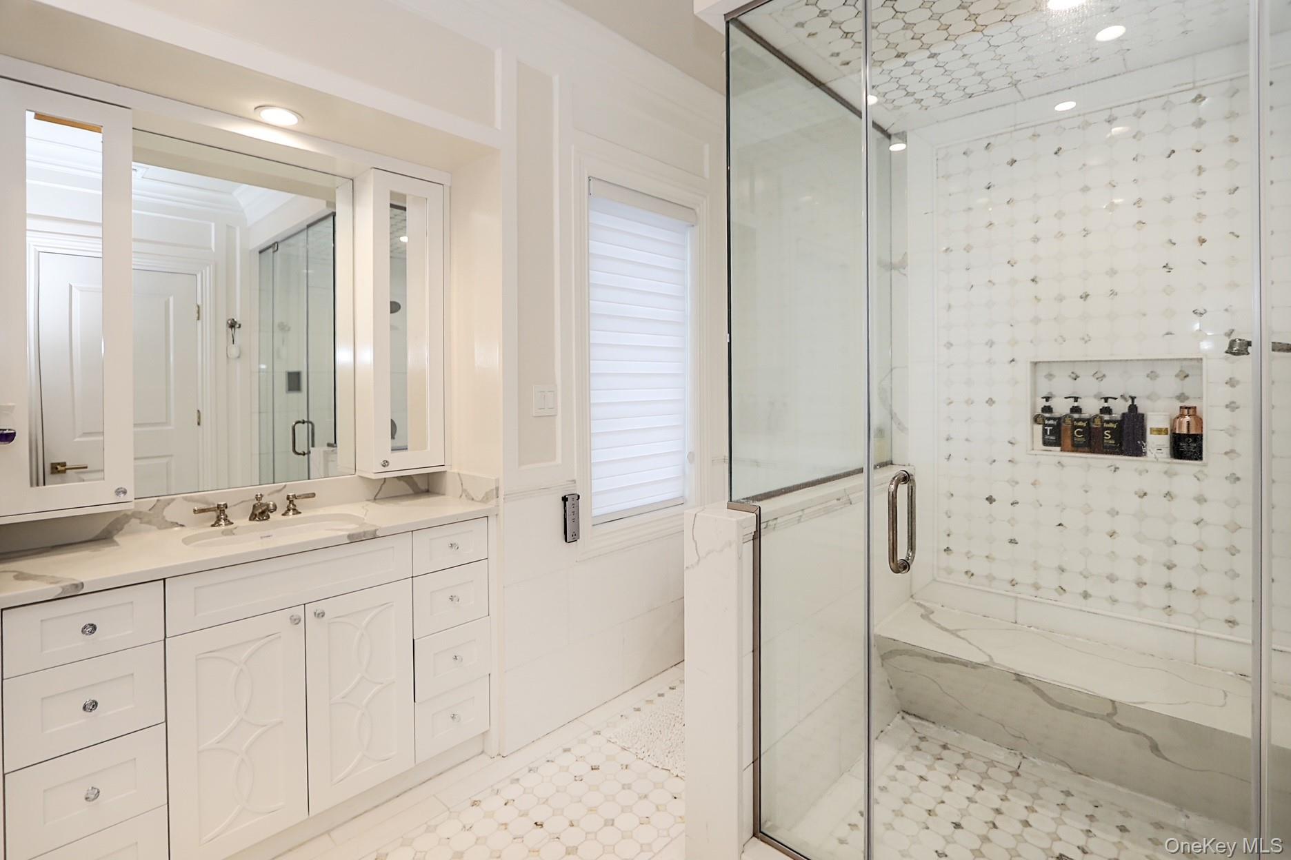 19 Gilbert Road Great Neck, NY 11024 - Photo 23 of 36 a bathroom with a granite countertop sink a mirror a shower and vanity