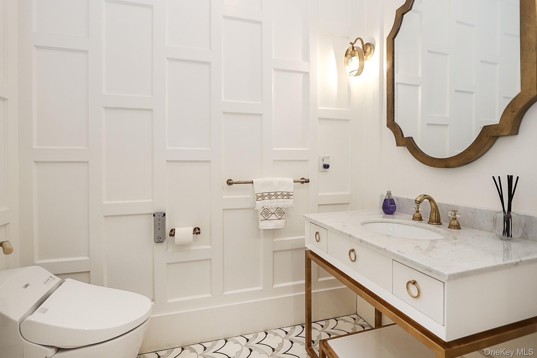 19 Gilbert Road Great Neck, NY 11024 - Photo 6 of 36 a bathroom with a sink a toilet and a mirror