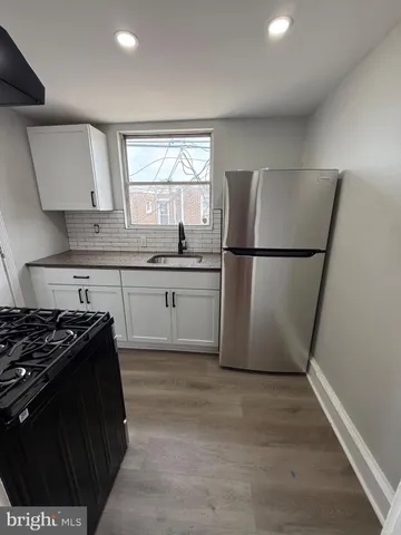 a kitchen with a stove a refrigerator and a sink