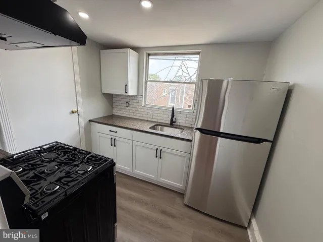 a kitchen with stainless steel appliances a refrigerator a sink and a window