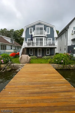 a front view of a house with a yard and potted plants