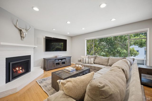 a living room with furniture a fireplace and a flat screen tv