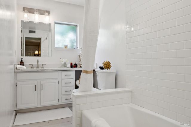 a bathroom with a bathtub sink vanity and mirror