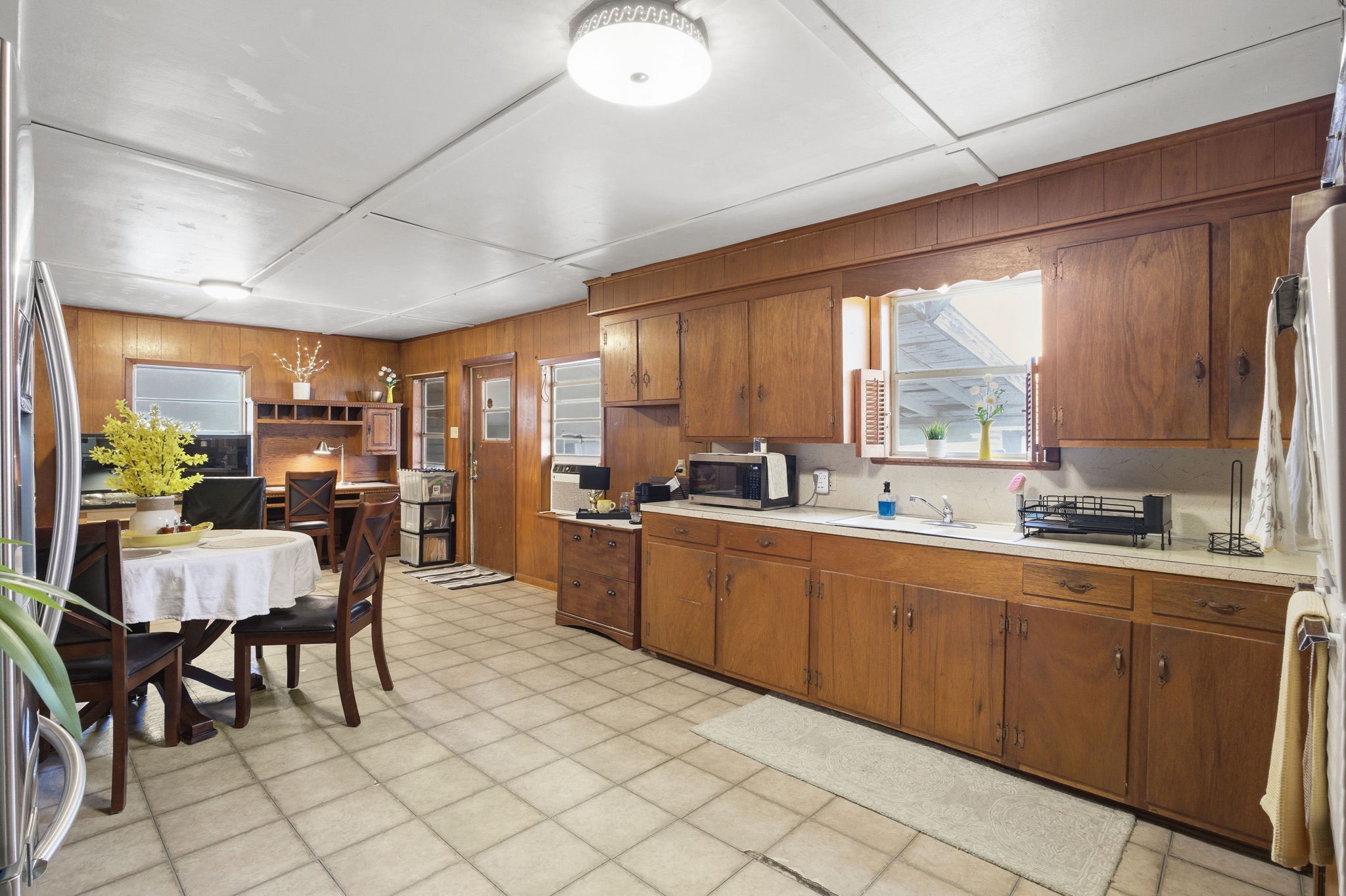 6902 Concord Road Beaumont, TX 77708 - Photo 9 of 18 a large kitchen with kitchen island granite countertop a dining table chairs and a refrigerator