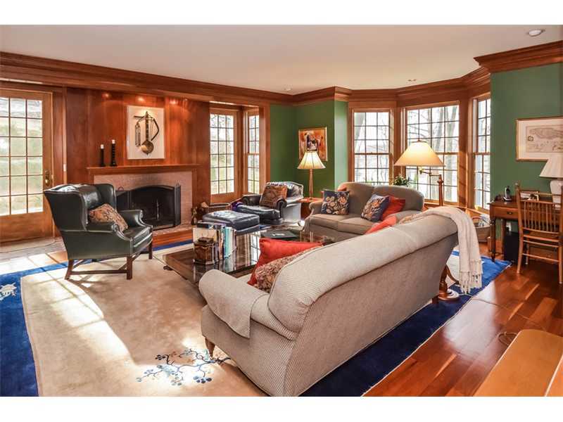 106 Goodwives River Road Darien, CT 06820 - Photo 11 of 24 a living room with furniture two large windows and a fireplace