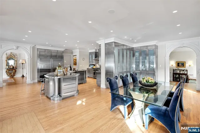 a kitchen with lots of wooden furniture dining table and chairs