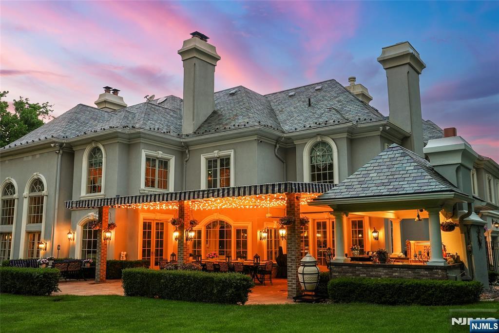 12 The Esplanade Alpine, NJ 07620 - Photo 34 of 41 a front view of a house with a garden and plants