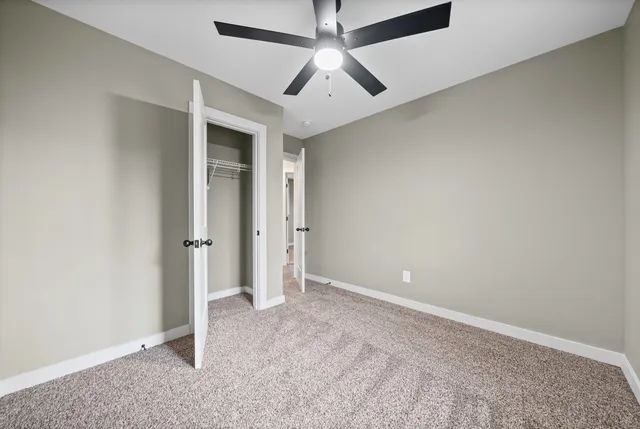 a view of yellow house with a big yard and large trees