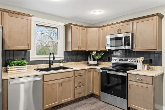 a kitchen with kitchen island granite countertop a sink stainless steel appliances and white cabinets