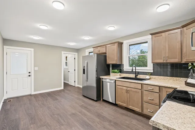 a kitchen with refrigerator cabinets and wooden floor