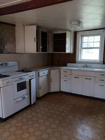 a kitchen with a stove sink and cabinets