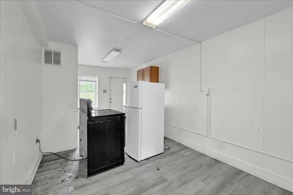 a view of a utility room with closet and wooden floor