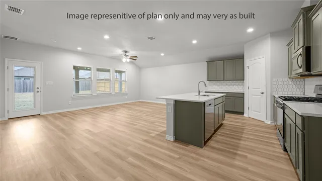 a large kitchen with stainless steel appliances granite countertop a large counter top and a wooden floors