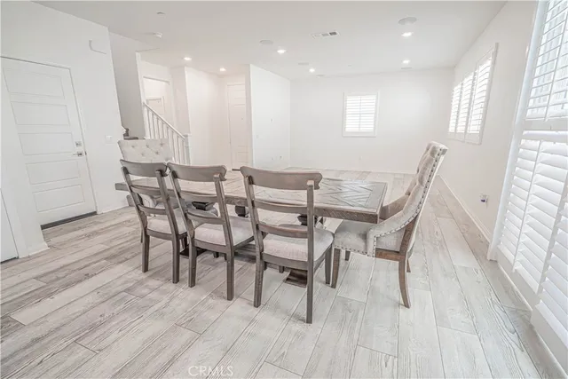 a large kitchen with stainless steel appliances granite countertop a table chairs sink and cabinets