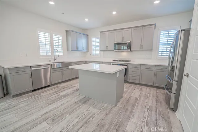 a kitchen with stainless steel appliances granite countertop a sink dishwasher stove top oven and refrigerator