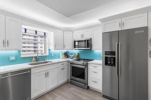 a kitchen with white cabinets and white appliances