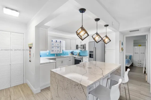 a view of a dining room and livingroom with furniture wooden floor a chandelier