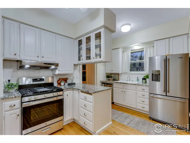 a kitchen with granite countertop a stove top oven and cabinets