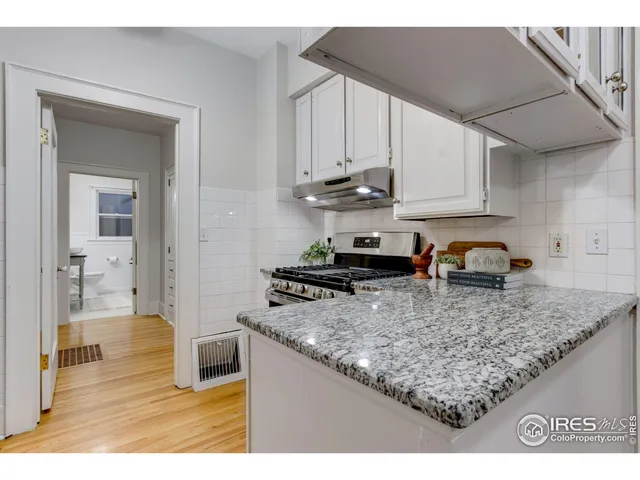 a kitchen with stainless steel appliances granite countertop a sink stove and cabinets