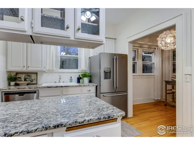 a kitchen with granite countertop a refrigerator and a stove top oven