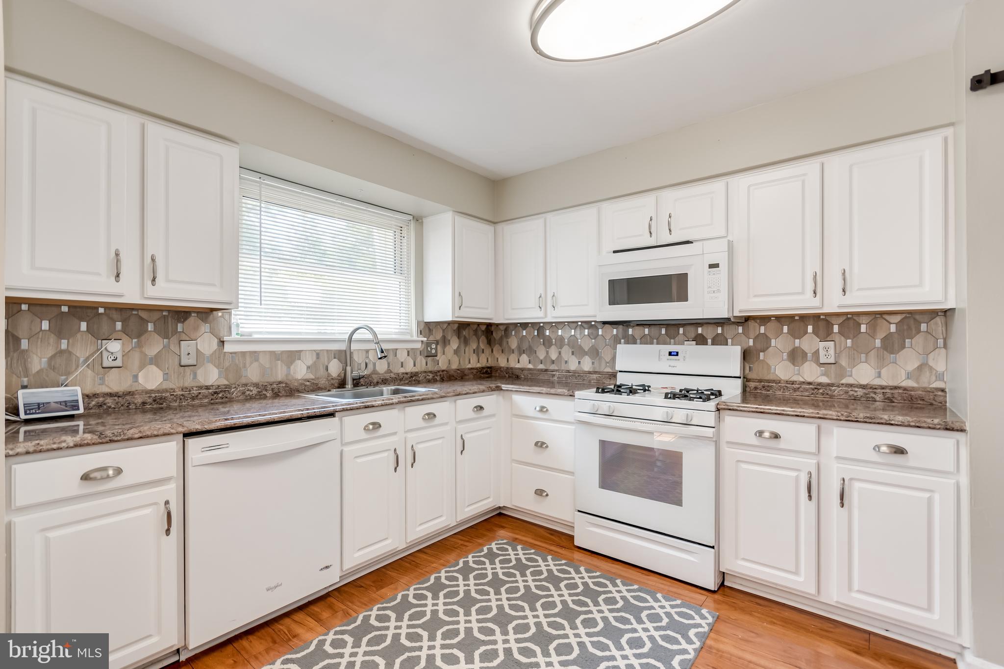 107 Capella Road Sewell, NJ 08080 - Photo 6 of 22 a kitchen with granite countertop white cabinets and white appliances