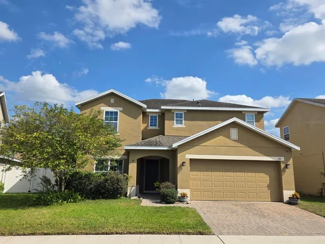 a front view of a house with a garden and plants