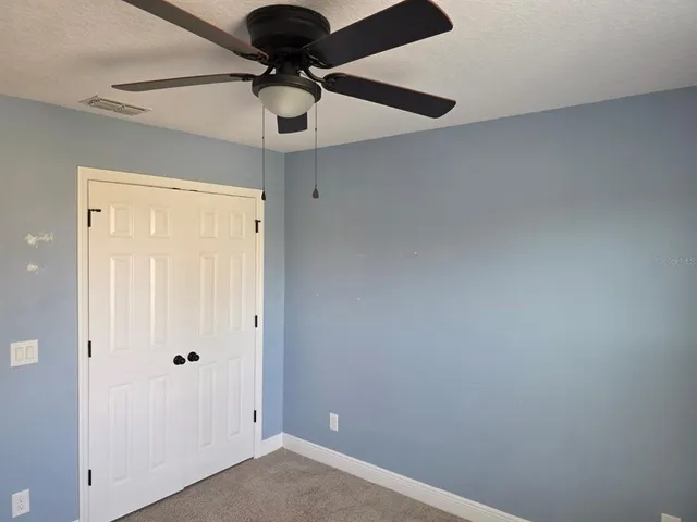 an empty room with a ceiling fan and a window