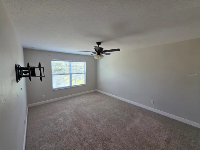 an empty room with a window and a fan