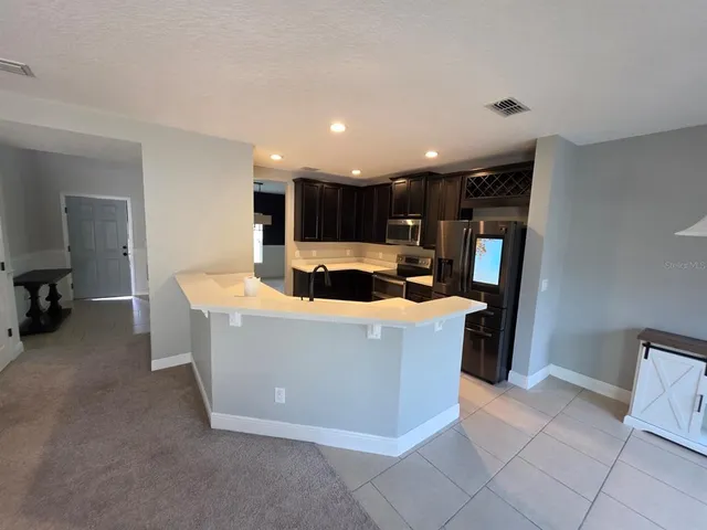 a living room with stainless steel appliances furniture a rug and a view