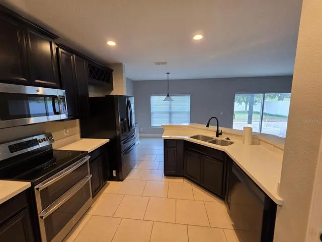a kitchen with stainless steel appliances sink stove top oven and cabinets