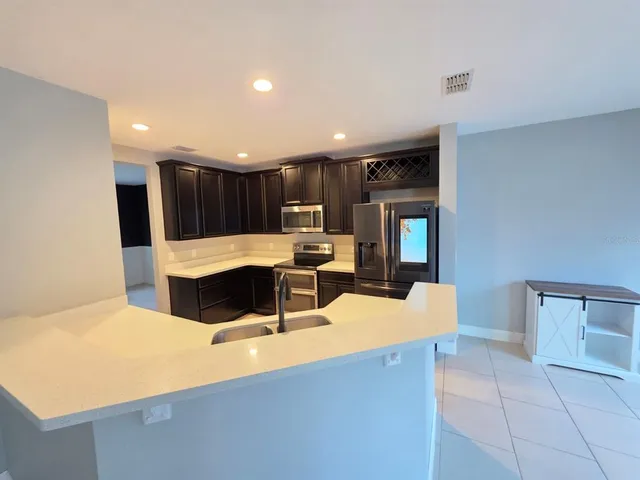 a large kitchen with kitchen island a sink a stove and a refrigerator