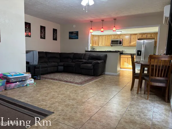 a living room with stainless steel appliances kitchen island granite countertop furniture and a large window