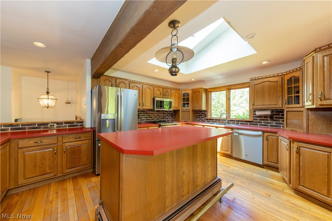 7969 Dines Road Novelty, OH 44072 - Photo 9 of 48 Spacious kitchen featuring hardwood flooring, large breakfast bar island,, oak cabinetry, and red countertops